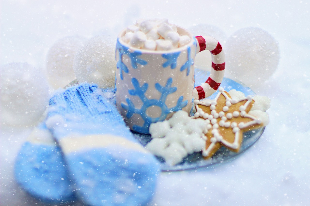 mittens, hot cocoa, and cookies on a snowy background